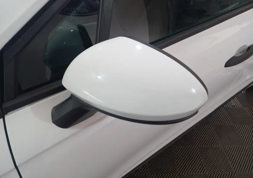 Rétroviseur côté gauche blanc de Renault Clio Air Nav Blue dCi 85, vue rapprochée sur porte et vitre teintée.