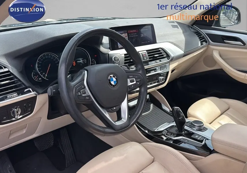 Intérieur beige clair de BMW X4 XDRIVE 30D 2019, vue du poste de conduite avec volant multifonction et console centrale moderne.