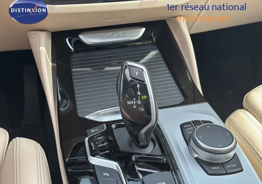 Gros plan sur la console centrale beige d’un BMW X4 XDRIVE 30D 2019, mettant en valeur le levier de vitesse automatique.