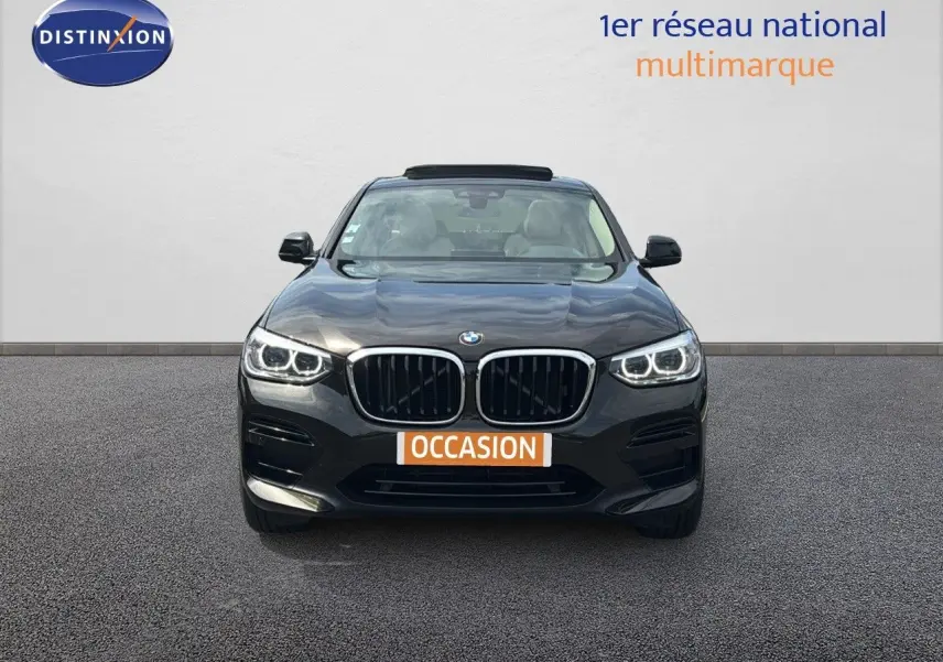 Vue frontale d'un BMW X4 XDRIVE 30D Sparkling Storm Métal avec phares LED allumés sur fond neutre.