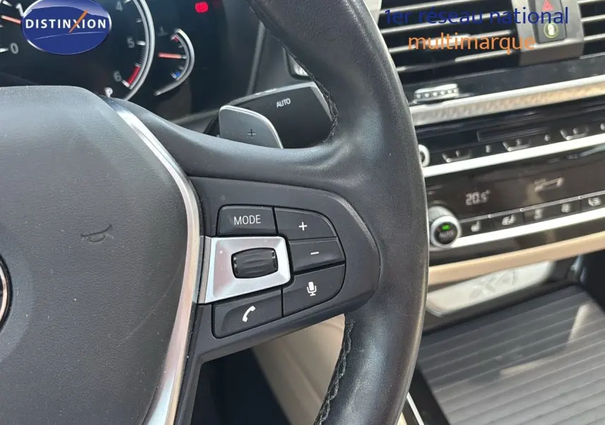 Gros plan sur le volant cuir noir et la console centrale du BMW X4 XDRIVE 30D Sparkling Storm Métal de 2019.