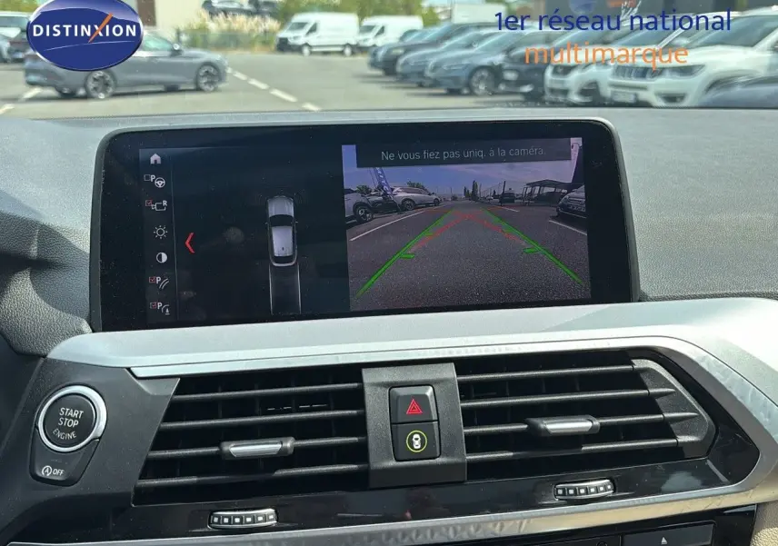 Écran central du BMW X4 30D 2019 montrant la caméra de recul avec les lignes de guidage vertes et rouges.