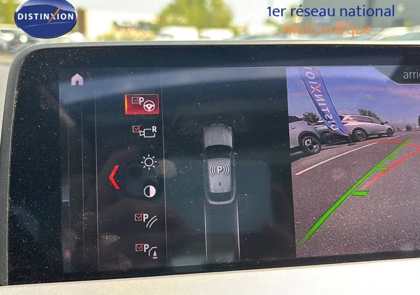 Écran de caméra de recul montrant l'arrière du BMW X4 Sparkling Storm Métal en stationnement avec guidage vert et rouge.