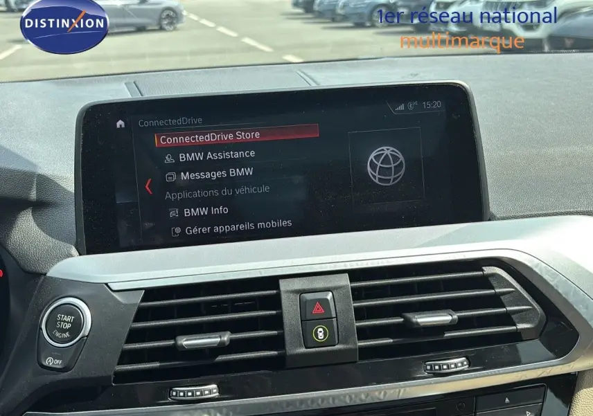 Vue rapprochée du tableau de bord du BMW X4 XDRIVE 30D 2019, écran connecté et commandes centrales visibles.