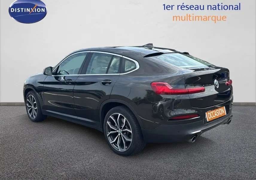 BMW X4 XDRIVE 30D Sparkling Storm métal vue 3/4 arrière côté gauche, avec jantes alliage et feux LED distinctifs.