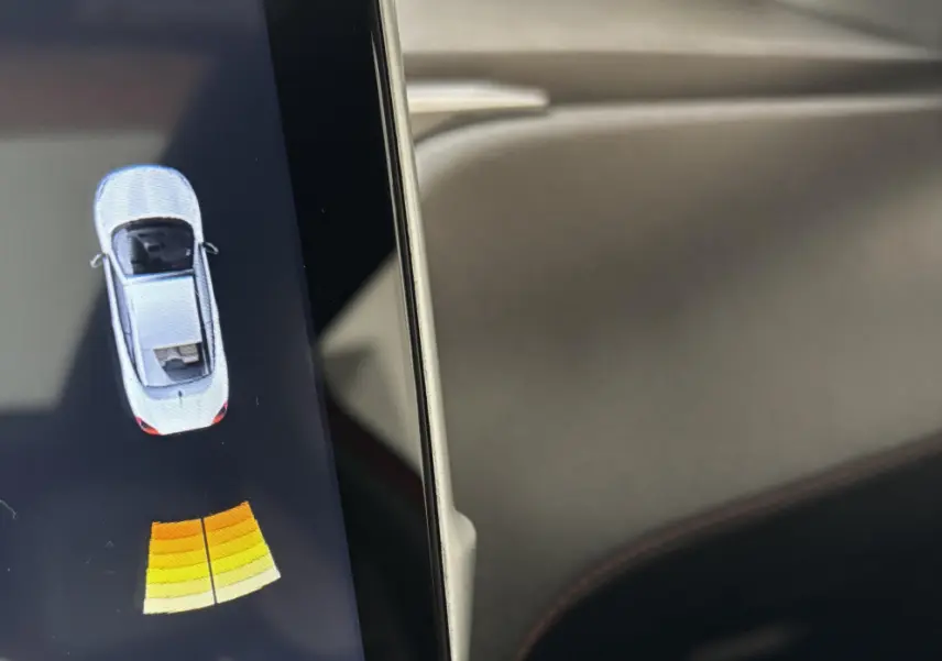 Affichage du capteur de distance au stationnement sur l'écran tactile intérieur d'une Peugeot 208 GTI rouge.