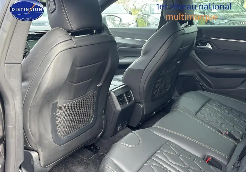 Vue intérieure arrière montrant les sièges en cuir noir et les aérateurs centraux d'une Peugeot 508 SW gris titane 2024.