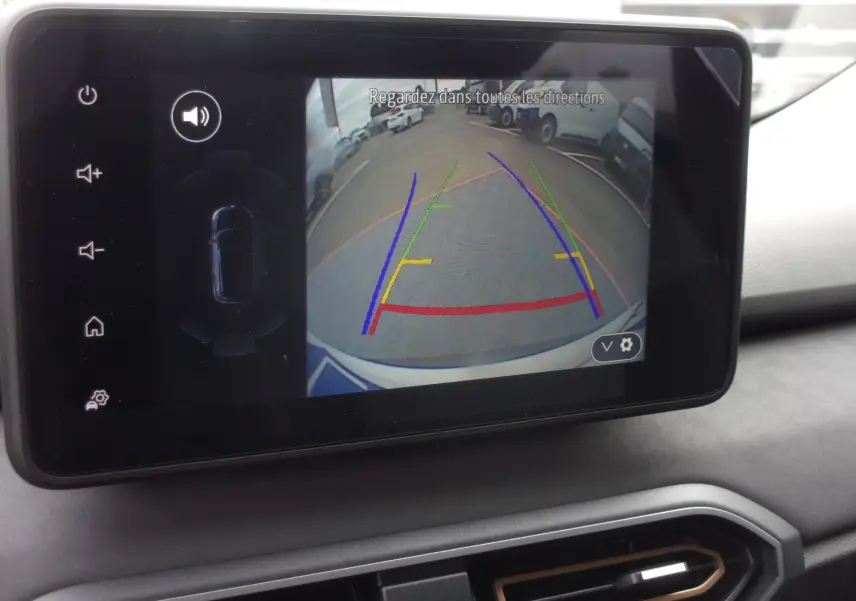 Écran multimédia du Dacia Jogger blanc 2025 montrant la caméra de recul avec lignes de guidage colorées.