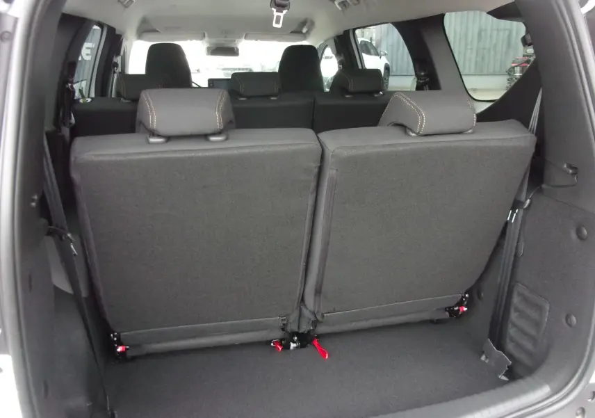 Vue arrière du coffre du Dacia Jogger blanc 2025, montrant les sièges arrière rabattus et l'espace de chargement.