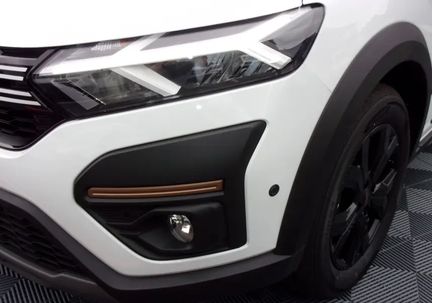 Gros plan sur le phare avant droit blanc du Dacia Jogger 2025 avec détail noir et jante noire.