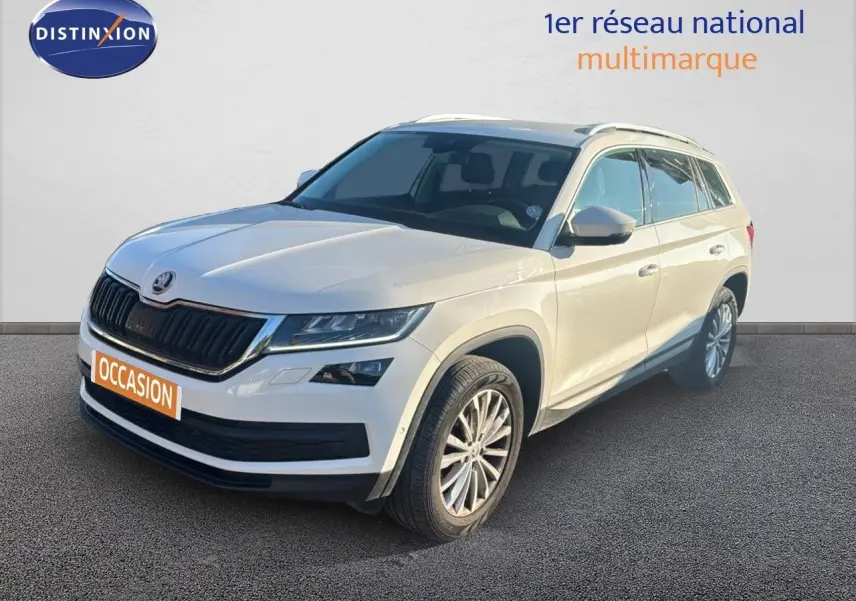 SUV Skoda Kodiaq blanc en 3/4 avant droit, avec calandre noire et jantes alliage visibles sur fond neutre.