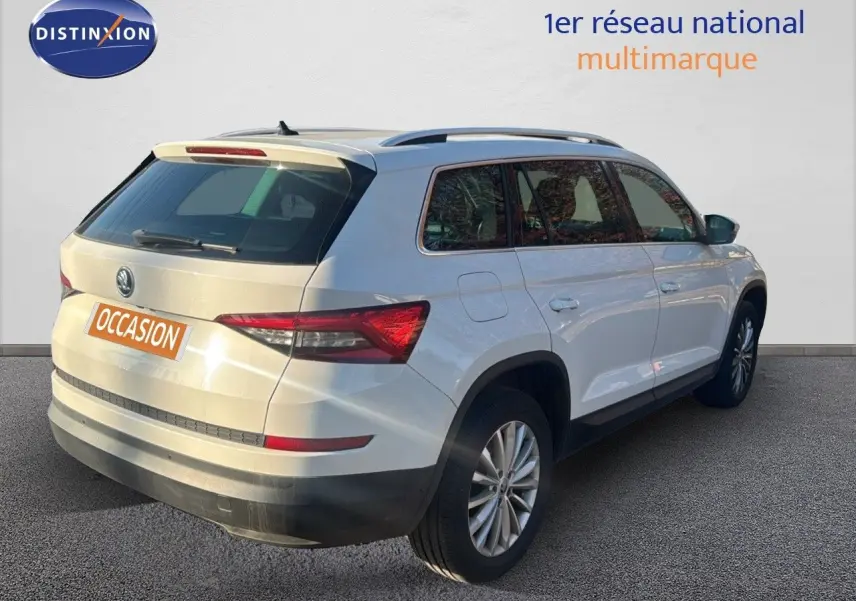 Vue 3/4 arrière droite d'un Skoda Kodiaq blanc 2018 avec jantes alliage et toit ouvrant visible.