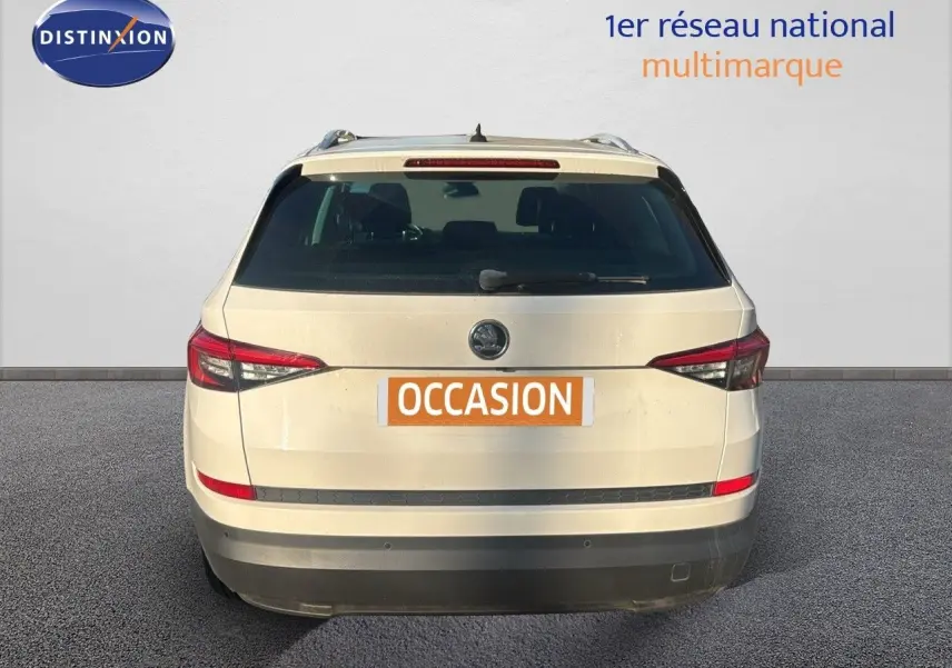 Vue arrière d'un SUV SKODA KODIAQ blanc de 2018 avec feux arrière effilés et hayon fermé sur fond neutre.