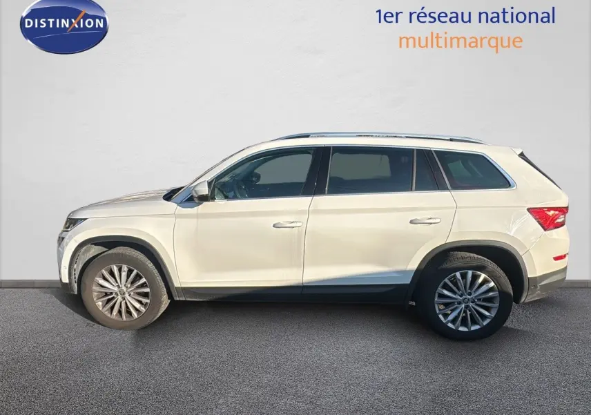 Profil côté gauche d'un SUV Skoda Kodiaq blanc 2018 avec jantes alliage et vitres teintées sur fond neutre.