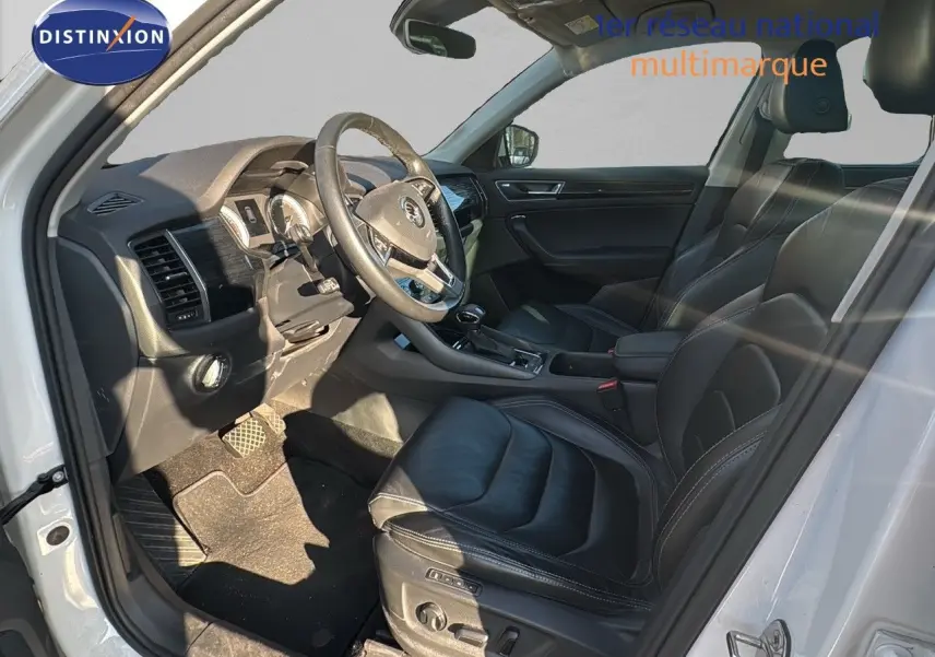 Intérieur noir cuir du Skoda Kodiaq blanc 2018, vue côté gauche sur le poste de conduite et les sièges avant.