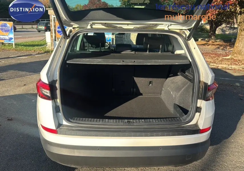 Vue arrière d'un SKODA KODIAQ blanc de 2018 avec coffre ouvert montrant un espace de chargement spacieux et noir.