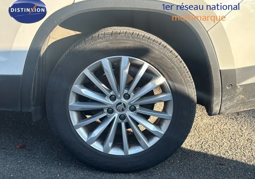 Gros plan sur la roue avant droite d'un Skoda Kodiaq blanc de 2018 avec jante alliage à rayons multiples.