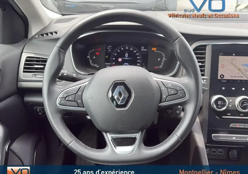 Vue intérieure centrée sur le volant cuir de la Renault Mégane IV Berline gris foncé avec tableau de bord numérique et écran tactile.