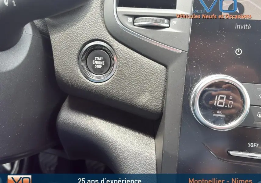 Bouton Start Engine Stop sur tableau de bord noir de Renault Megane IV Berline gris foncé, détail intérieur côté conducteur.