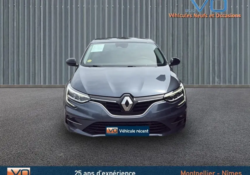 Vue frontale d'une Renault Mégane IV Berline gris foncé avec phares LED et calandre chromée visible sur fond neutre.
