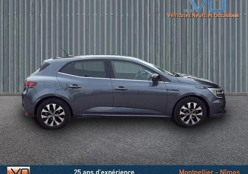 Profil côté droit de la Renault Mégane IV gris foncé avec jantes alliage et rétroviseurs électriques rabattables.