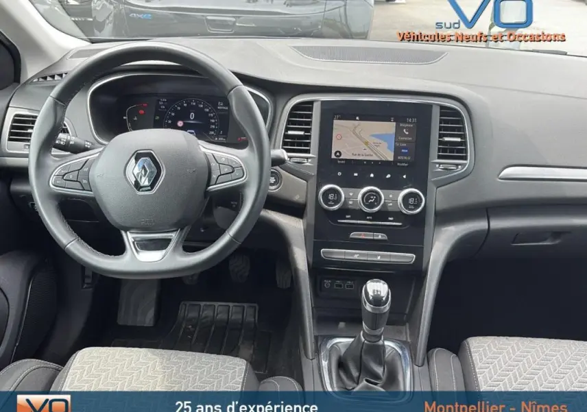 Intérieur de la Renault Mégane IV Berline gris foncé, vue frontale du tableau de bord avec volant et écran tactile central.
