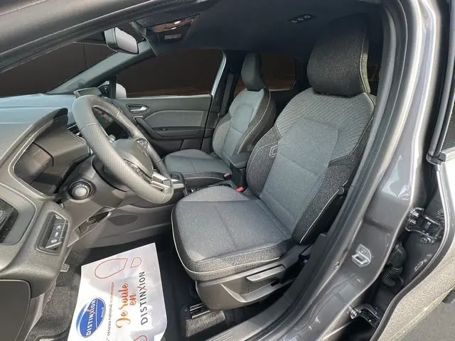 Vue intérieure côté conducteur du Renault Captur 2025 gris Cassiopée, sièges tissu gris et volant multifonction.