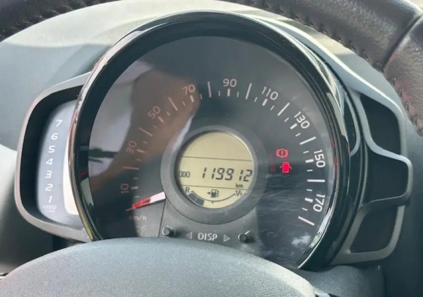 Gros plan sur le compteur de vitesse et compte-tours du tableau de bord de la Citroën C1 rouge Scarlet de 2014.