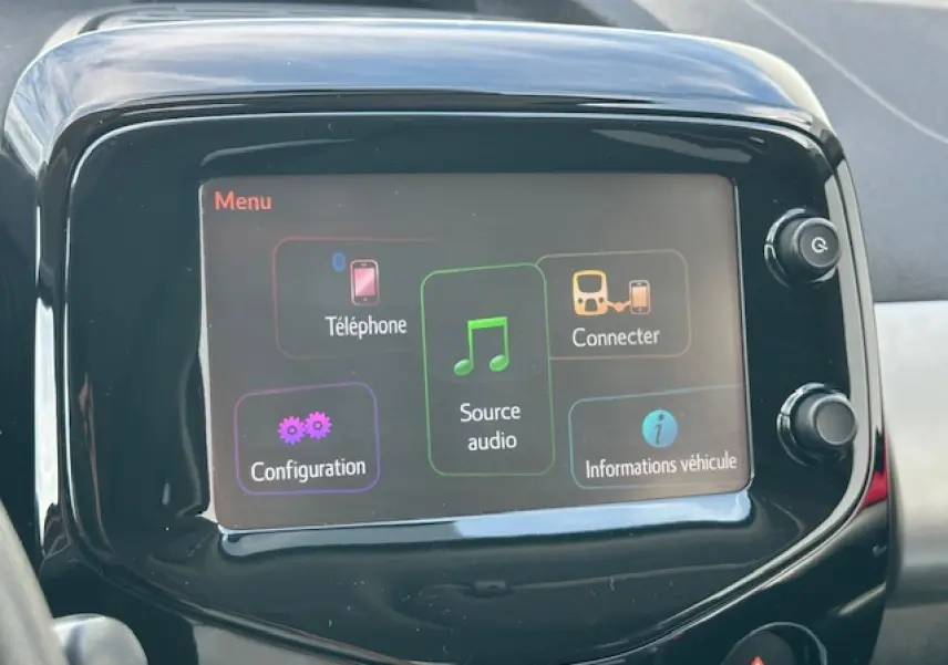Écran tactile central de la Citroën C1 rouge Scarlet de 2014 affichant le menu multimédia avec options connectivité et audio.