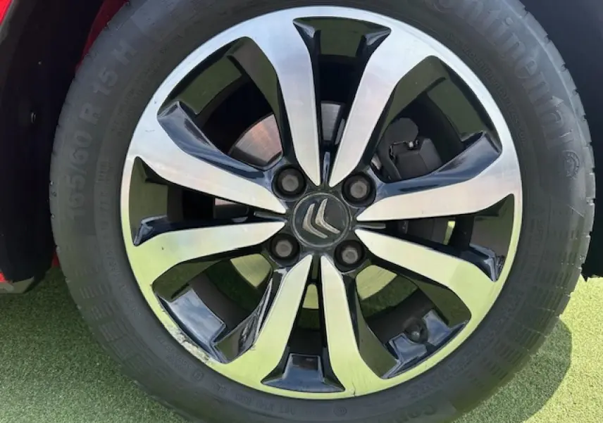 Gros plan sur la jante alliage 15 pouces bicolore noir et argent du Citroën C1 Rouge Scarlet de 2014.