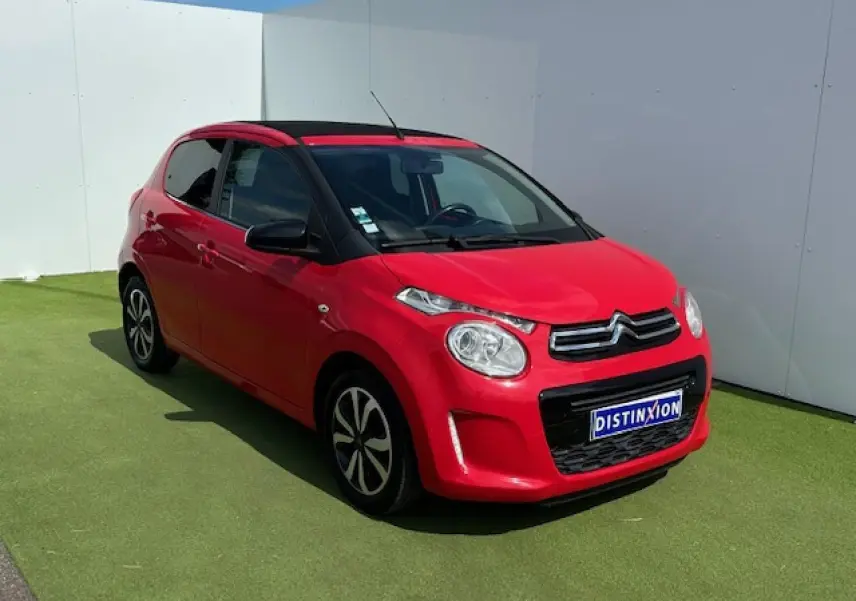 Citroën C1 rouge Scarlet vue 3/4 avant droit avec toit ouvrant et jantes alliage noires et argentées.
