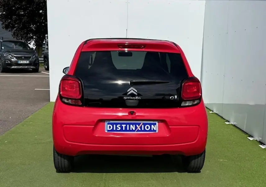 Vue arrière d'une Citroën C1 rouge Scarlet avec lunette arrière noire et feux arrière carrés.