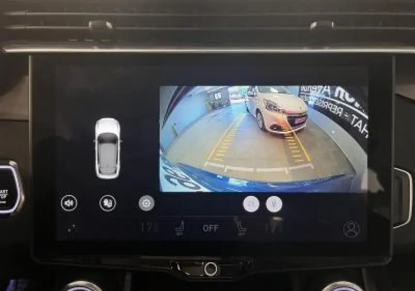 Écran tactile montrant la caméra de recul du LYNK & CO 01 bleu avec guidage de stationnement en garage.