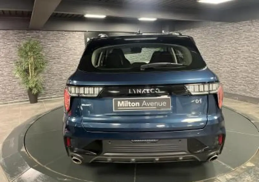 Vue arrière d'un SUV LYNK & CO 01 bleu métallisé avec double sortie d'échappement et feux arrière LED.