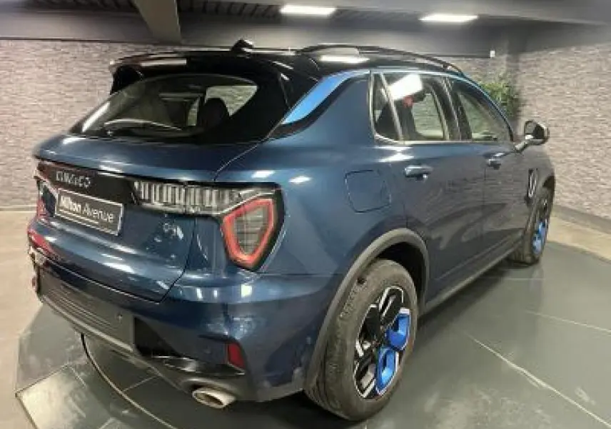 Vue 3/4 arrière droite du SUV Lynk & Co 01 bleu avec jantes bicolores et feux arrière LED distinctifs.
