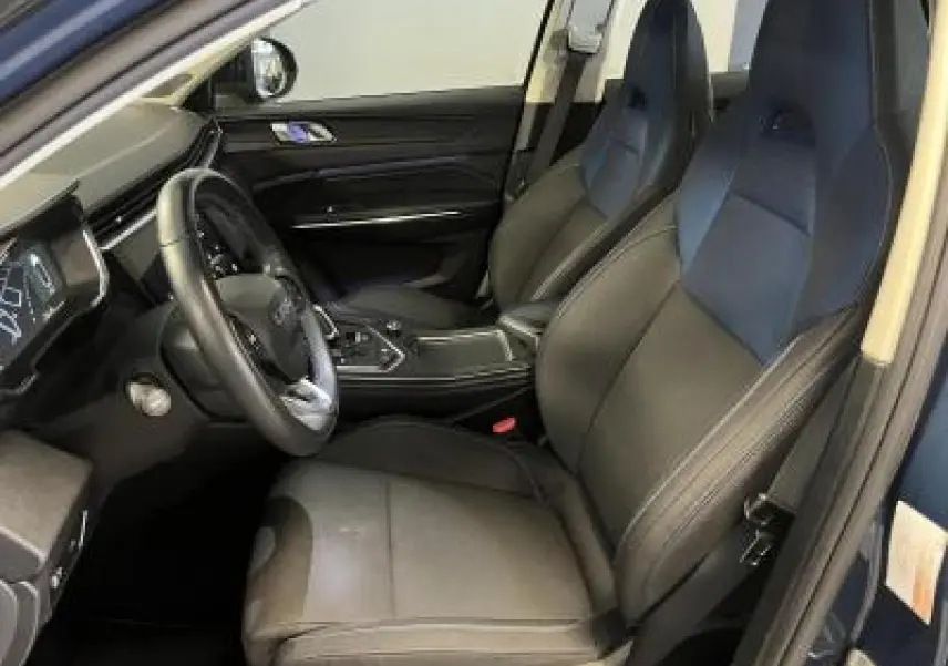 Intérieur avant droit du LYNK & CO 01 bleu, sièges tissu noir et tableau de bord moderne avec écran digital.