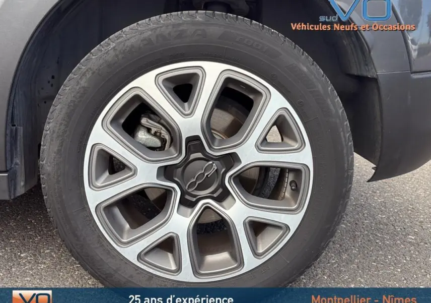 Gros plan sur la jante alliage 17 pouces et le pneu d'un FIAT 500X gris anthracite côté avant droit.