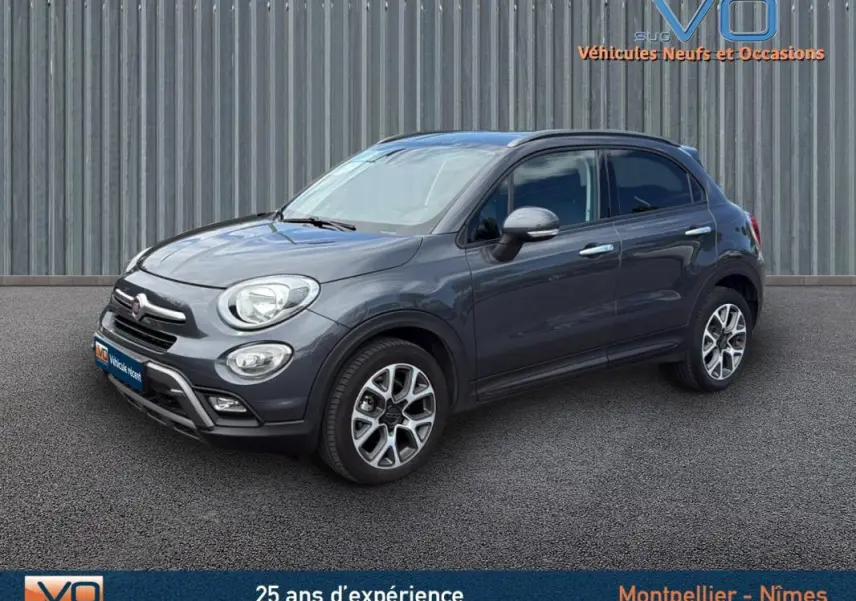 Fiat 500X gris anthracite vue 3/4 avant droit, jantes alliage 17 pouces et phares antibrouillard visibles.