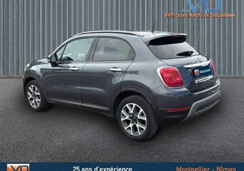 FIAT 500X gris anthracite vue 3/4 arrière côté gauche, jantes alliage 17 pouces et vitres teintées.