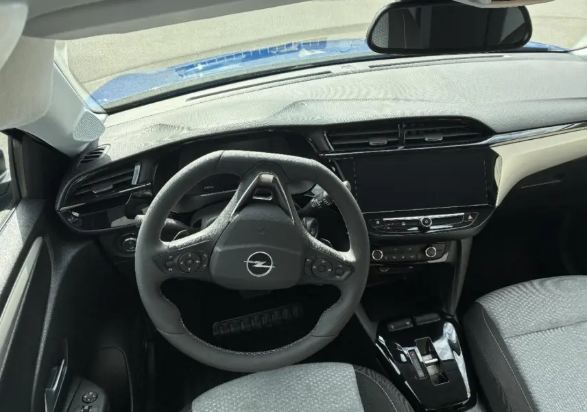 Vue intérieure de face de l’Opel Corsa 2025 gris kristall, montrant le volant multifonction et l’écran tactile central.