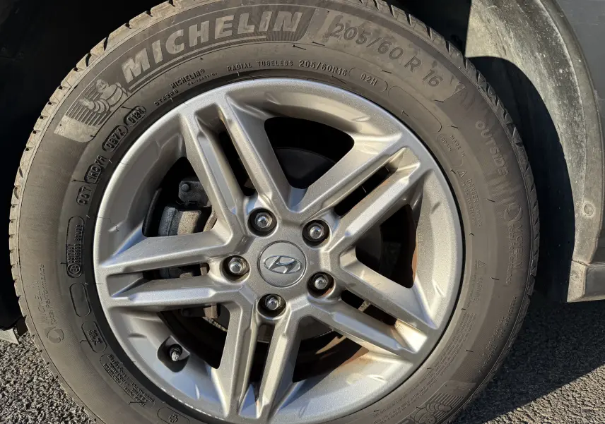 Gros plan sur la roue avant droite d'un Hyundai Kona blanc Atlas 2021 avec jante alliage et pneu Michelin.