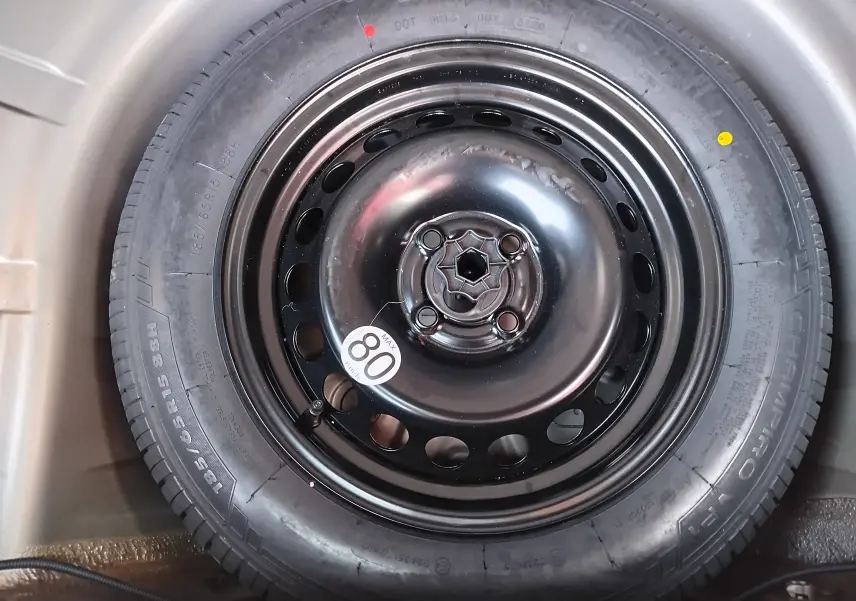 Gros plan sur la roue de secours noire avec étiquette 80 km/h du Dacia Sandero Stepway beige dune 2020