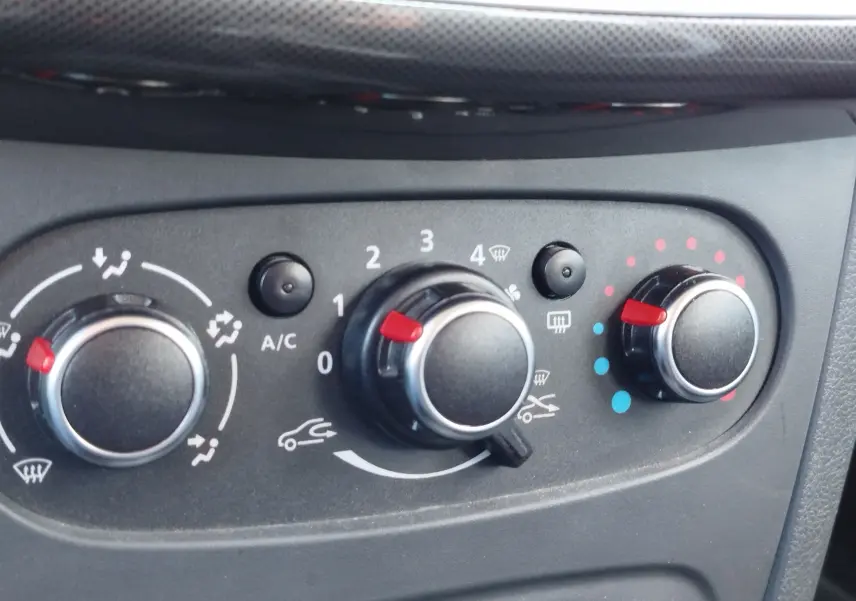 Gros plan sur les commandes de climatisation du tableau de bord de la Dacia Sandero Stepway beige dune de 2020.