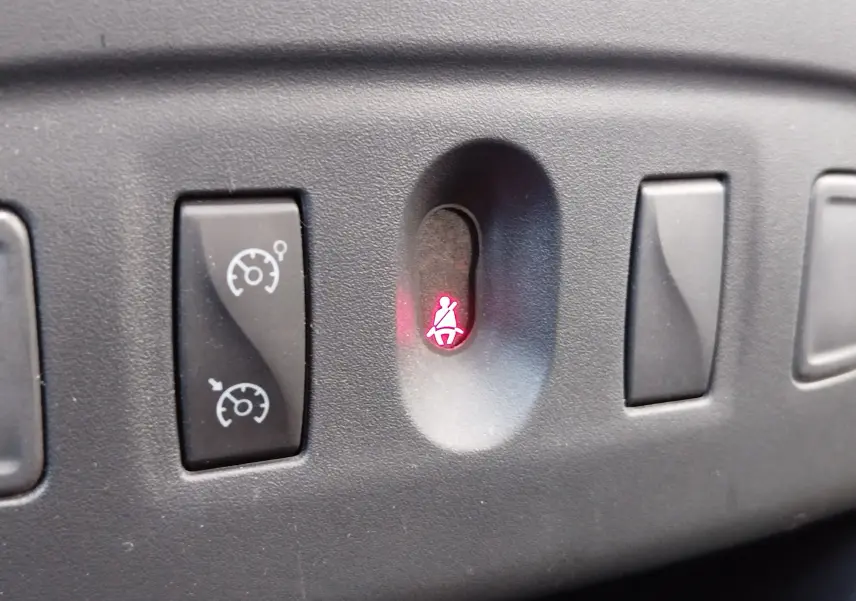 Gros plan sur le tableau de bord d'une Dacia Sandero Stepway 2020, voyant de ceinture allumé en rouge.
