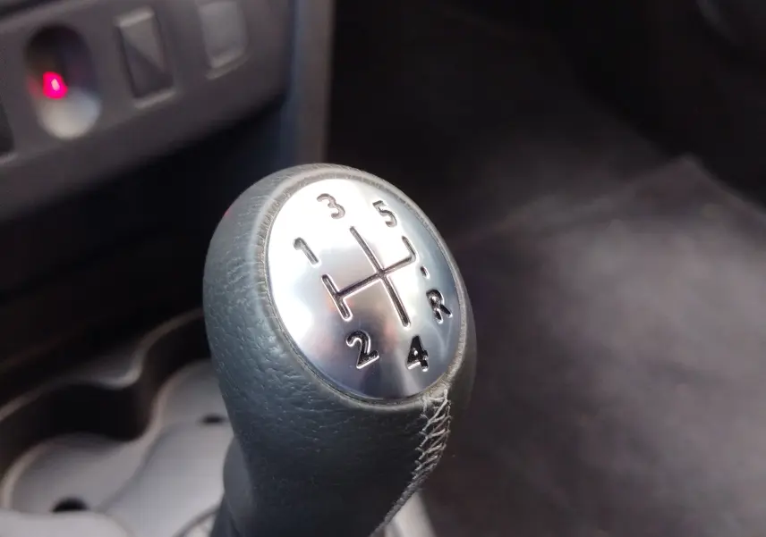 Le levier de vitesse manuel en cuir noir de la Dacia Sandero Stepway 2020, intérieur sombre.