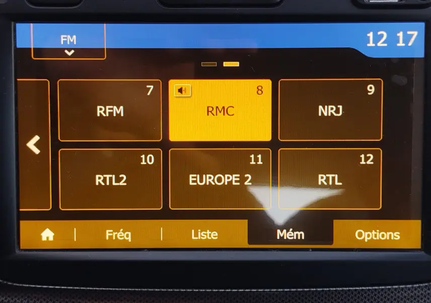 Écran tactile multimédia de la Dacia Sandero Stepway 2020 affichant les stations radio FM avec interface orange et noire.
