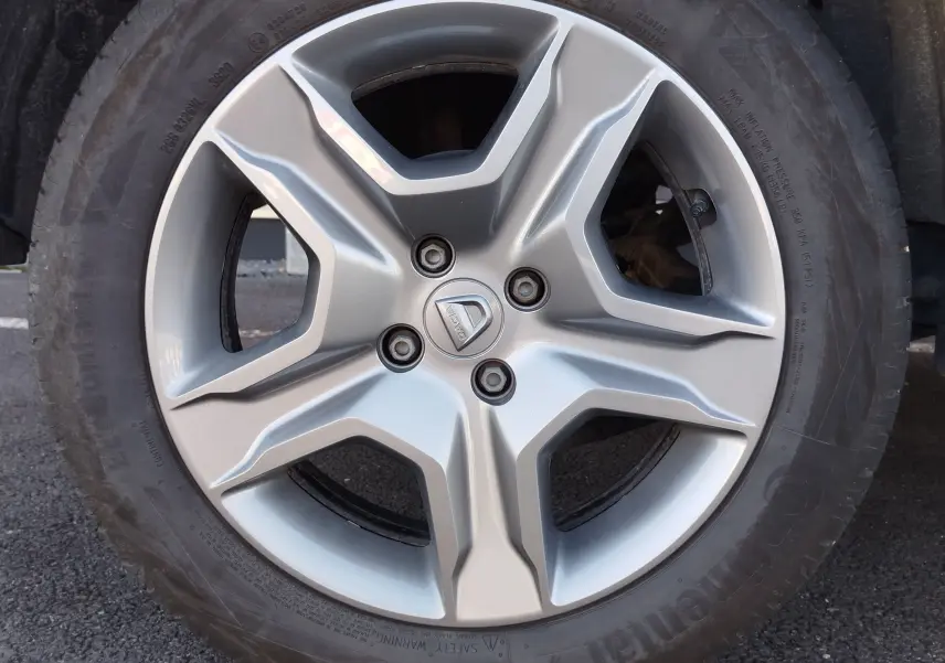 Gros plan sur la roue arrière droite d'une Dacia Sandero Stepway beige dune de 2020, mettant en valeur le pneu et l'aile.