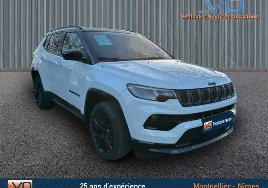 Jeep Compass blanc vue 3/4 avant droit avec jantes alliage noires et barres de toit visibles