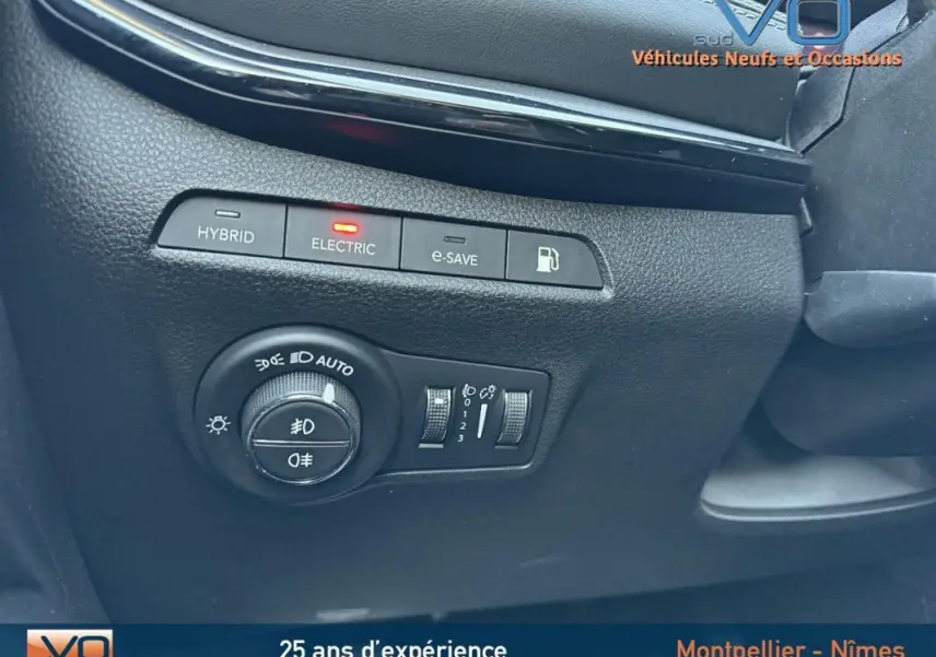 Vue rapprochée des commandes d'éclairage et mode électrique du Jeep Compass blanc 2023, intérieur noir.