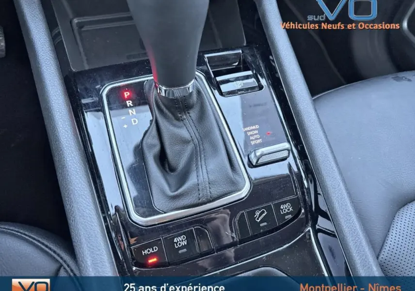 Gros plan sur la console centrale noire avec levier de vitesse automatique du Jeep Compass blanc 2023 hybride.